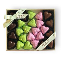 Heart-shaped chocolate pralines, mixed colors pink green brown, gift box with ribbon