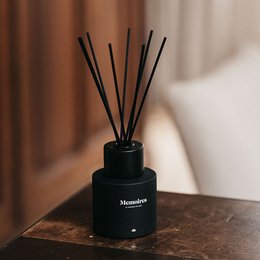 Elegant black glass diffuser with long black reeds, designed to disperse fragrance throughout a room.