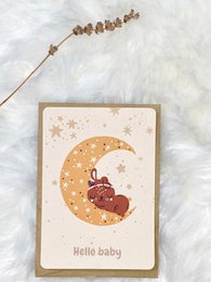 Adorable birthday card featuring a sleeping baby on a crescent moon surrounded by stars. Warm, neutral color palette with a cozy, whimsical design.
