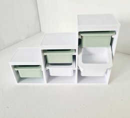 A set of white stackable storage boxes, suitable for use as dollhouse accessories. The boxes have a simple, minimalist design with clean lines and a light green interior.
