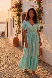 Blue and white patterned midi dress with long sleeves and a v-neck. Made of a lightweight, flowing fabric.