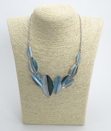 Elegant rhodium-plated metal necklace with a striking leaf-shaped pendant design.
