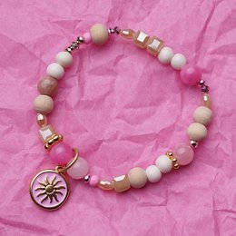 Pink and white beaded bracelet with sun charm pendant, gold accents, gemstone beads.
