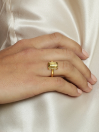 Chocolate gold-colored ring with a square-shaped stone, designed to be stacked with other rings.
