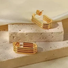 Gold and silver statement earrings with a layered, geometric design.