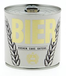 A round, tall cake with a golden label that says "BIER" and features wheat stalks. The cake has a single lit candle on top.