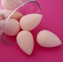 Makeup sponge applicator in a pink teardrop shape, designed for seamless blending and application of makeup.