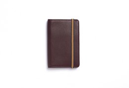 Burgundy leather card holder with elastic band closure and interior card slots.