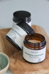 "Calming botanical bath salts in glass jars with black lids, natural ingredients, spa relaxation product"