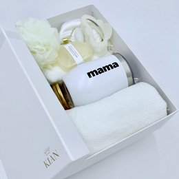 White gift box with elegant wellness and beauty products, including a mug with the word "mama" printed on it.