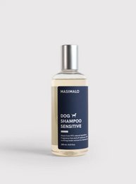 Sensitive dog shampoo in a clear glass bottle with a silver cap. The shampoo is designed for dogs with sensitive skin and coats.