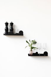 Black cloud-shaped wall shelf, modern minimalist design, decorative storage for plants and small items.