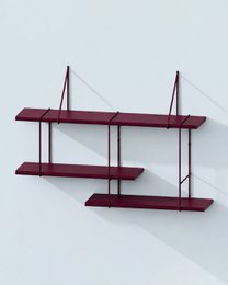 A modern, minimalist red shelving unit displaying various decorative items and books.