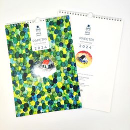 The image shows a 2024 wall calendar featuring illustrations of tiny houses in a nature-inspired setting. The calendar pages display various scenes with colorful patterns, animals, and landscapes. The product appears to be a decorative wall calendar suitable for home or office use.