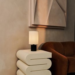 A black table lamp with a beige cylindrical shade and an E27 fitting.