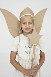A young girl wearing a DIY fairy costume with large cardboard wings and a white dress.