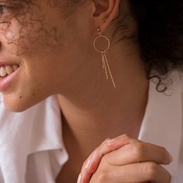 Elegant gold-tone stud earrings with a circular design and dangling chain accents, perfect for adding a touch of sophistication to any outfit.