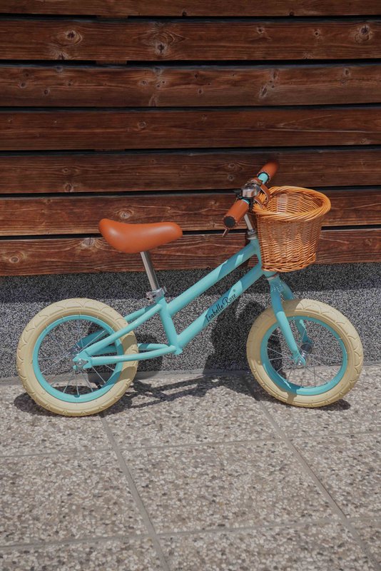 Balancecykel i pastelblå farve med flettet kurv Isabelle Rose