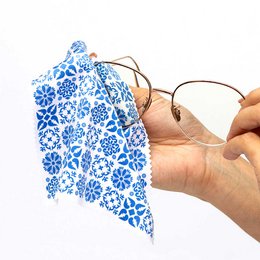 Blue microfiber eyeglass cloth with geometric tile pattern, snowflake and floral designs, soft cleaning fabric.