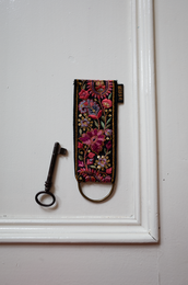 Paisley Dark keychain with D-ring and musketon, featuring a vibrant floral embroidered pattern in shades of pink, red, and black.