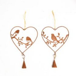 A heart-shaped garden sculpture featuring a bird perched on a branch. The sculpture is made of metal and has a rustic, natural appearance with a warm brown color.