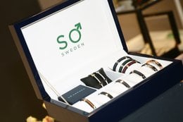 A display box containing various charm bracelets. The box is black and features the "SO" logo, indicating it is a product from the SO brand.