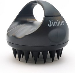 A silicone scalp massager with a rounded, ergonomic shape and multiple color options including red, purple, black, yellow, gray, green, pink, and blue. The massager features soft bristles to gently stimulate the scalp and promote blood circulation.
