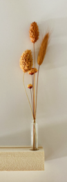 Dried flower arrangement featuring a bundle of dried flowers in neutral tones, including orange, beige, and white. The flowers have a natural, rustic appearance and are displayed on a wooden stand.