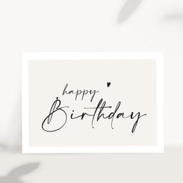 A handwritten "Happy Birthday" greeting card with a green leaf wreath and white plates on a light background.