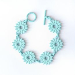 Flower Chain Bracelet - Dahlia Aqua, a delicate and feminine charm bracelet featuring a chain of aqua-colored daisy-like flowers.