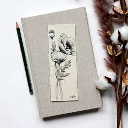 Handmade bookmark made of grass paper, featuring a floral design with poppies. The bookmark has a natural, earthy aesthetic.