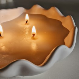 Scented candle with a unique wavy shape, available in Mangue Papaye, Monoï de Tahiti, and Sunset Dream fragrances. Made of high-quality wax for a long-lasting, soothing burn.