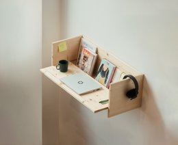  "Compact wall-mounted desk with natural wood and white surface, storage compartments, round handles, minimalist design."