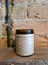 Vintage vegan soy travel candle with oak and tobacco scent, in a glass jar with a black lid.