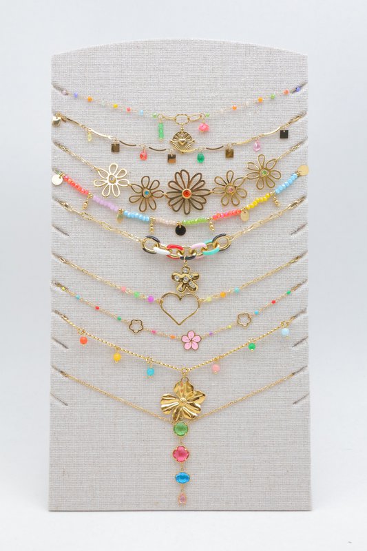 Lot de 9 colliers multicolores assortis en acier inoxydable, présentés sur un support en tissu de lin avec pied de soutien à l'arrière. Présentoir et bijoux prêts à être exposés directement. L'ensemble est livré et protégé sous papier bulle