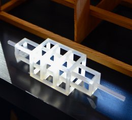 Small white geometric sculpture with triangular shapes, made of a modern, minimalist design.