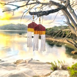 Handmade gold-colored earrings with red and white beaded tassels, featuring a unique and eye-catching statement design.