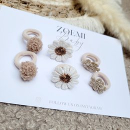 Mini elastic hair ties in neutral fall colors, including beige, brown, and white floral designs.