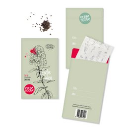 A green seed bag with the text "Sowing Love" printed on it. The bag contains various flower seeds and a small packet of soil.