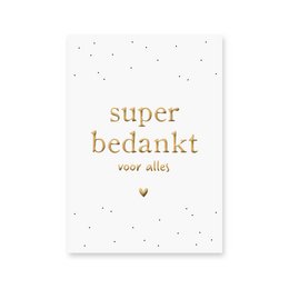 A white card with gold foil text that reads "super bedankt voor alles" (super thank you for everything).