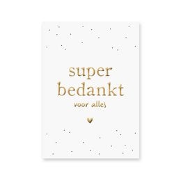 A white card with gold foil text that reads "super bedankt voor alles" (super thank you for everything).