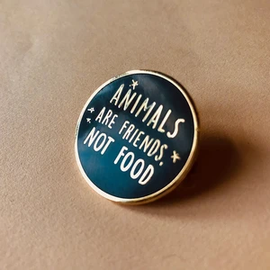 Veganer Emaille-Pin „Tiere sind Freunde, kein Essen“.