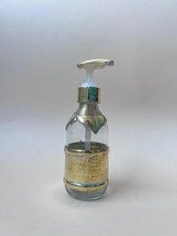 Glass soap dispenser pump bottle, small round clear container, gold glitter base, metallic silver pump top