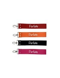Colorful fabric keychains with "Parfaite" text. Available in red, orange, black, and pink. Compact and durable design for everyday use.