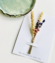 A colorful bouquet of dried flowers, including wheat stalks and purple flowers, presented on a white card with the text "For the sweetest you".