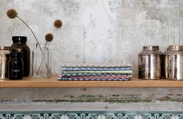 "Half linen tea towel with a checkered pattern in various colors including blue, gray, green, and red. The towel measures 47 x 70 cm and is made of a durable linen material."