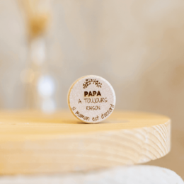 A cork and wood wine bottle stopper with the text "Papa a toujours raison" (Dad is always right) engraved on it. The stopper has a rustic, natural appearance that would make a thoughtful gift for a father.