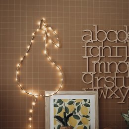A pear-shaped lamp with string lights, creating a warm and whimsical atmosphere in a cozy kids' room.