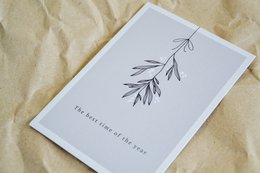 A simple, minimalist postcard with a hand-drawn branch illustration and the text "The best time of the year" printed below.