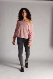  Women's skinny jeans with a pink off-the-shoulder top. The jeans have a slim, form-fitting silhouette and the top features a relaxed, casual style.